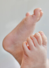 Bare baby feet lifted upward, showing soft skin and tiny toes