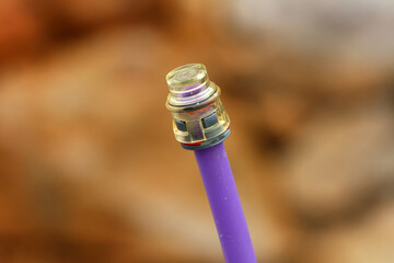 Detailed macro of a fiber optic cable with a clear connector tip, showing modern telecommunications...