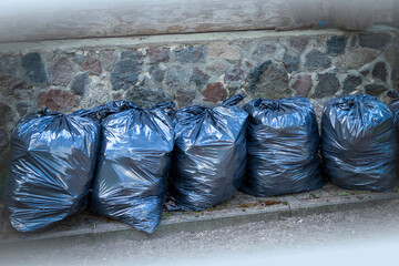 Black plastic garbage bags along the wall.