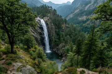 Fototapeta premium Majestic waterfall cascades down rocky cliffs in a lush forest valley