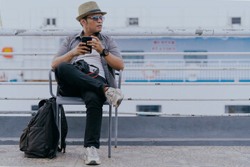 Passenger tourist traveler asian man using mobile cell phone app while traveling sitting relaxed on...