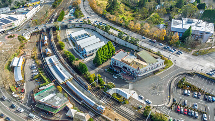 Drone aerial photograph of a train arriving and departing at the Katoomba Train Station near the Great Western Highway in the Blue Mountains, NSW, Australia.
