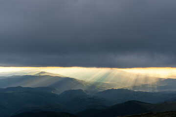 yellow beautiful sun and clouds over the mountains