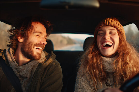 Happy young couple laughing together while sitting in a car. Carefree travel vibes on a sunny day.