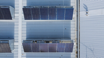 Drone aerial photograph of an array of Solar Panels located on the roof of a commercial building.