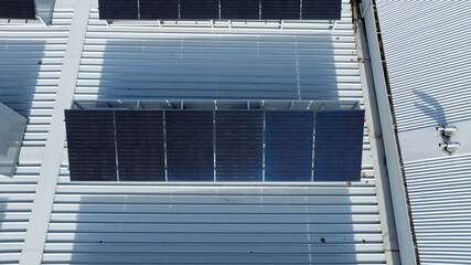 Drone aerial photograph of an array of Solar Panels located on the roof of a commercial building.