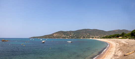 Beach with boats and hillside houses, Corsica