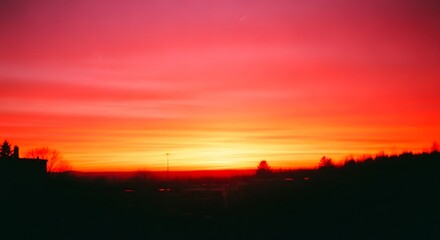 Obraz premium Vibrant Sunset over Horizon An Intense Sky Painting of Crimson and Gold at Dusk, Silhouette of trees and buildings with Dramatic Light