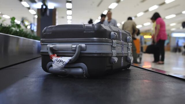 Close-Up Tracking Shot of Luggage Rolling Through Airport Checkout Area