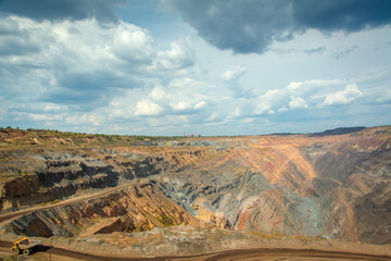 Work of trucks and the excavator in an open pit on gold mining, soft focus