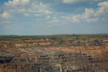 Work of trucks and the excavator in an open pit on gold mining, soft focus