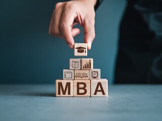 Hand stacking wooden blocks with mba letters and education business icons symbolizing career advancement and academic achievement