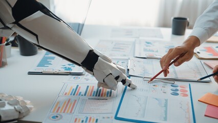 A robot arm assists a human in analyzing business data during a meeting, showcasing the blend of...