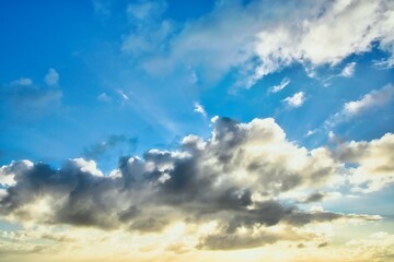 New Zealand sky replacement of a setting sun that is trying to hide behind sone dark clouds.