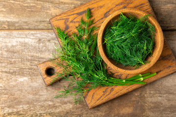 Dill on wooden background. Fresh organic greens. Dill plantation. Cut dill leaves. Bunch of spring...