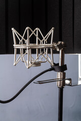 Silver spider microphone holder on a stand on a gray background