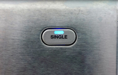 Metal button with single written on it