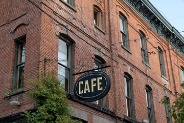 Obraz premium Brick building with cafe sign, aged facade and vintage windows on a historic urban structure