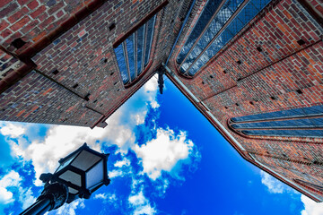 Low angle view of a historic red brick church with a lantern and dramatic blue sky filled with...