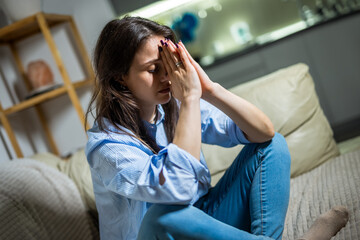 Depressed Young Woman Sitting Alone in Her Living Room