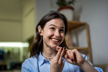 Happy Young Deaf Woman Using Sign Language with Hearing Aid