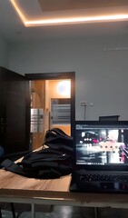 Laptop on a wooden desk with a black bag near an open door and a light panel on the ceiling ai generated 