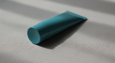 Turquoise Tube Lying on Surface in Natural Light
