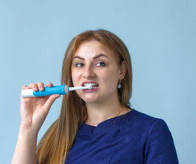 a portrait of a dentist who shows how to brush your teeth with an electric brush.