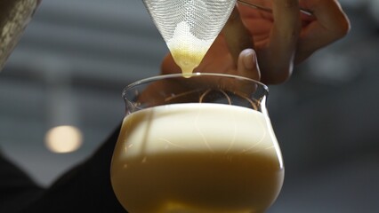 Closeup hand bartender using strainer in all ingredients alcohol liquor and syrup tasty in cocktail...