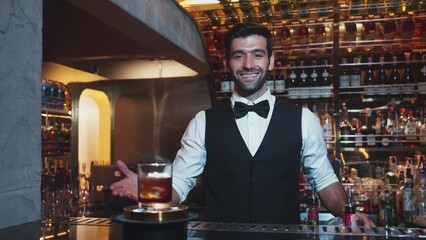 Focusing on serving mist smoky classical Old fashioned whiskey cocktail presentation cooling...