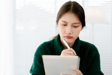 Portrait of a young woman taking notes in an office.
A young accountant is working on tax accounts...