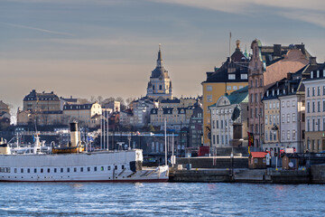 Historic Gamla Stan waterfront in Stockholm with ferries and church spire