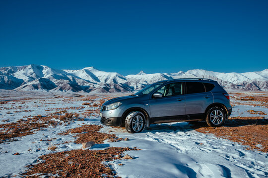 Kyrgyzstan - January 02, 2025: Nissan Qashqai car standing on high mountains background on winter day