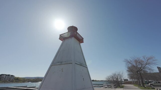 Low-angle view of Jackson Point Lighthouse with red and white colors glowing in sunlight