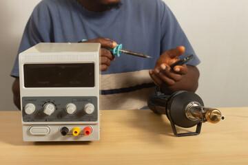 man soldering phone circuit board electronics repair workshop