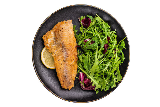 Roasted Haddock fish fillet on a plate with salad isolated on white background. top view