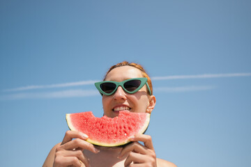 Tourist enjoying watermelon slice on sunny beach
