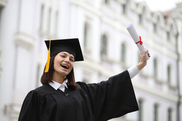 A happy graduate in cap and gown smiles and celebrates, the concept of education