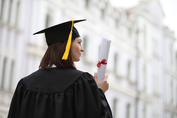 A happy graduate in cap and gown smiles and celebrates, the concept of education