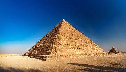majestic egyptian pyramid standing tall against a clear blue sky sunlit sands surrounding it imposing shadow