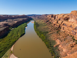 Beautiful Colorado River Through Red Desert Landscape With Towering Sandstone Canyon in Moab Utah