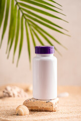 Bottle with capsules of the supplements vitamin d on the background of the sunny beach with sand in a white plastic jar. Vitamin D, fish oil. Healthy eating concept. High quality photo