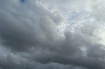 Stormy sky with dark, snowy clouds on a spring day. Clouds are floating across the sky. Dark blue clouds swiftly floating across blue sky. Storm dramatic clouds are floating across the sky. Hurricane.