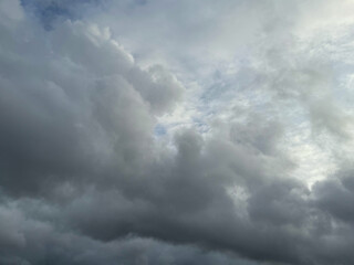 Stormy sky with dark, snowy clouds on a spring day. Clouds are floating across the sky. Dark blue clouds swiftly floating across blue sky. Storm dramatic clouds are floating across the sky. Hurricane.
