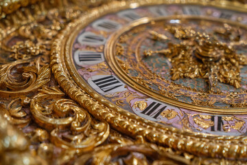Obraz premium Exquisite golden clock with intricate details showcasing Roman numerals and ornate craftsmanship