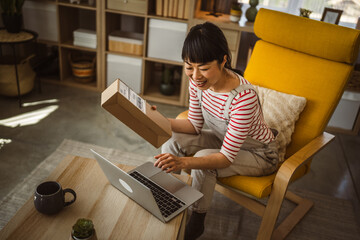 Fototapeta na wymiar one japanese woman checking box of received package or product at home