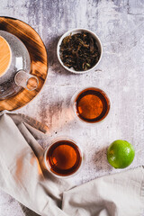 Home brewed earl grey tea in cups and teapot on table top and vertical view