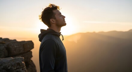 Man Meditating at Sunrise on Mountaintop Finding Peace and Serenity
