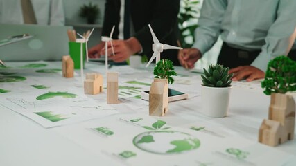 A group of diverse professionals collaborates on a sustainability project, showcasing green energy solutions and nature concepts through various materials and innovative ideas. SACTR - Powered by Adobe