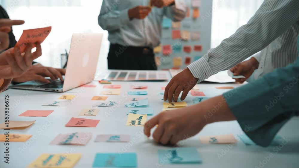 Poster dynamic office scene featuring a diverse team engaged in a brainstorming session using colorful stic
